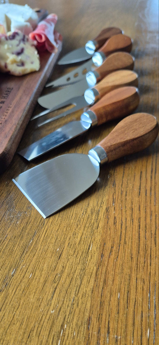 Close-up detail of the durable blades and ergonomic handles on a 6-piece premium cheese and meat knife set for artisan chopping boards.