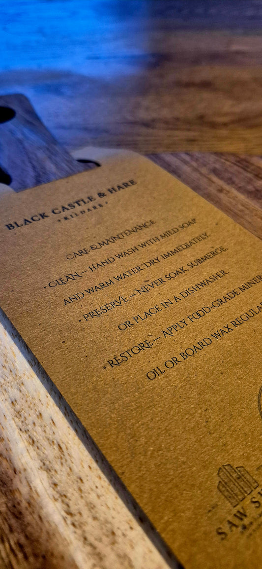 Close-up shot showing the 100mm handle and convenience hole for hanging the 300mm round acacia pizza charcuterie board with a kraft care card