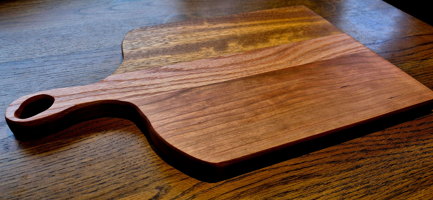 A 390mm x 235mm handcrafted wooden serving board with a slim handle, sized perfectly for cheese and meat displays.