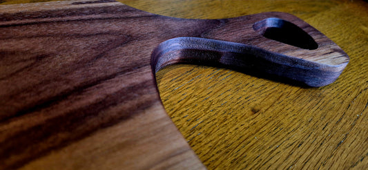 Overhead view of a slim 635×145 mm solid Walnut charcuterie board for long dining tables.