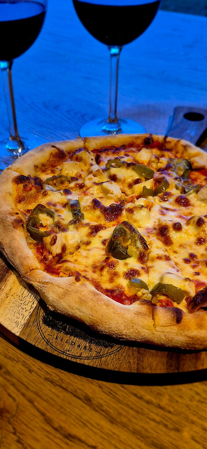 Close-up of gourmet pizza served on a food-safe double-oiled 300mm round acacia wooden board by Black Castle & Hare Kildare