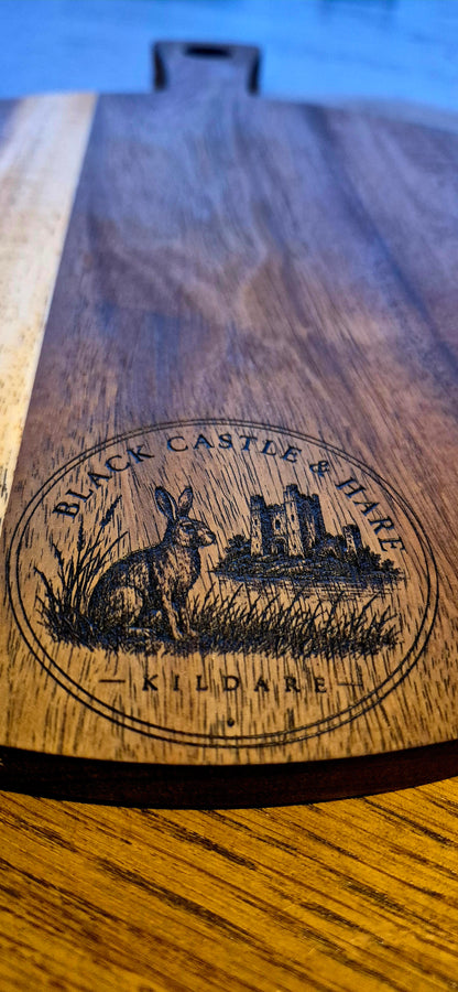 Angled view of artisan pizza board served on a 300mm round acacia wooden pizza board with black castle and hare kildare logo closeup