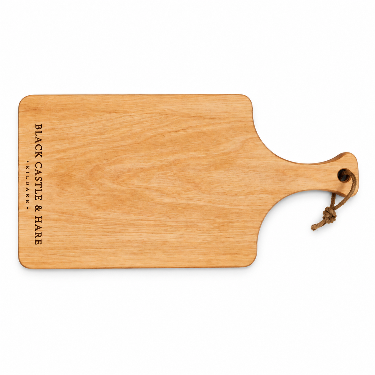 A rectangular wooden serving board with rounded corners and a handle, shown on a plain white background. The board has the text 'BLACK CASTLE & HARE FARMER'S MARKET' printed vertically on the left side and a small brown rope loop attached to the handle.