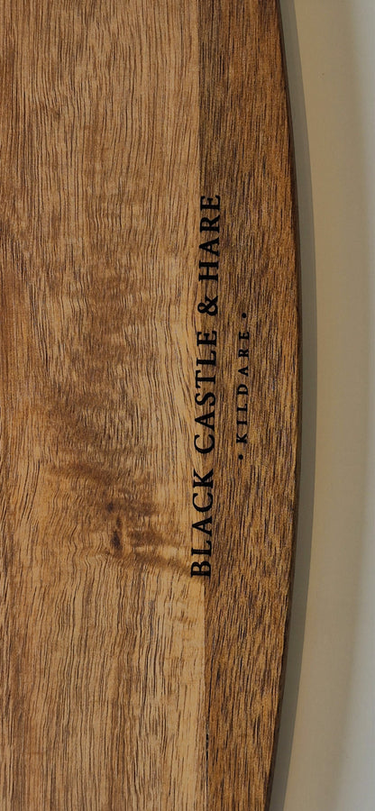Close-up of a wooden surface with vertical black text reading 'BLACK CASTLE & HARE' and smaller text 'Kildare' beside it.