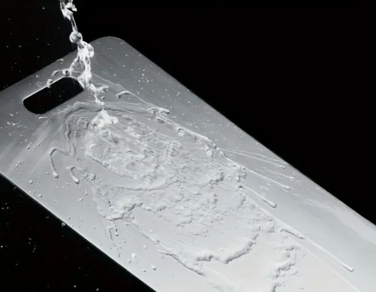 Dishwasher‑safe metal board being rinsed under tap
