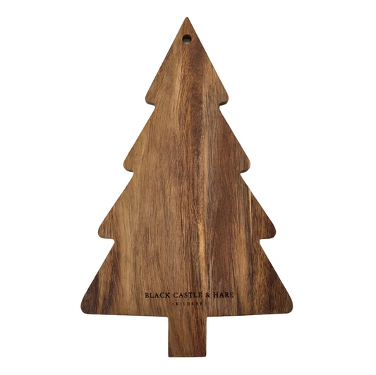A Christmas tree-shaped wooden cutting board with a natural wood grain finish, featuring the engraved text 'BLACK CASTLE & SHARE' on a white surface.