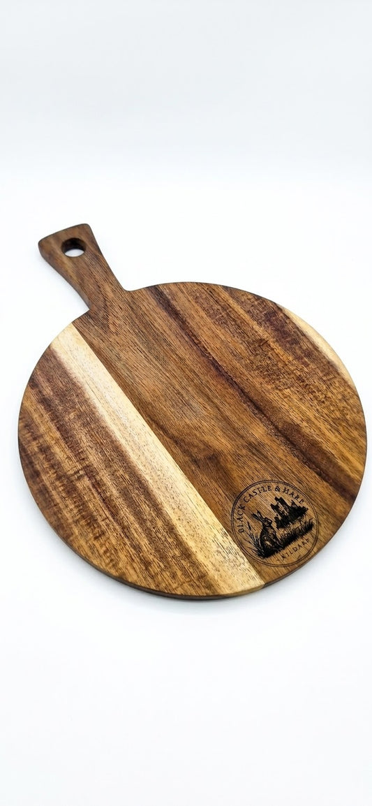 Round 300mm acacia pizza and charcuterie board with 100mm handle double oiled by Black Castle & Hare Kildare on white background