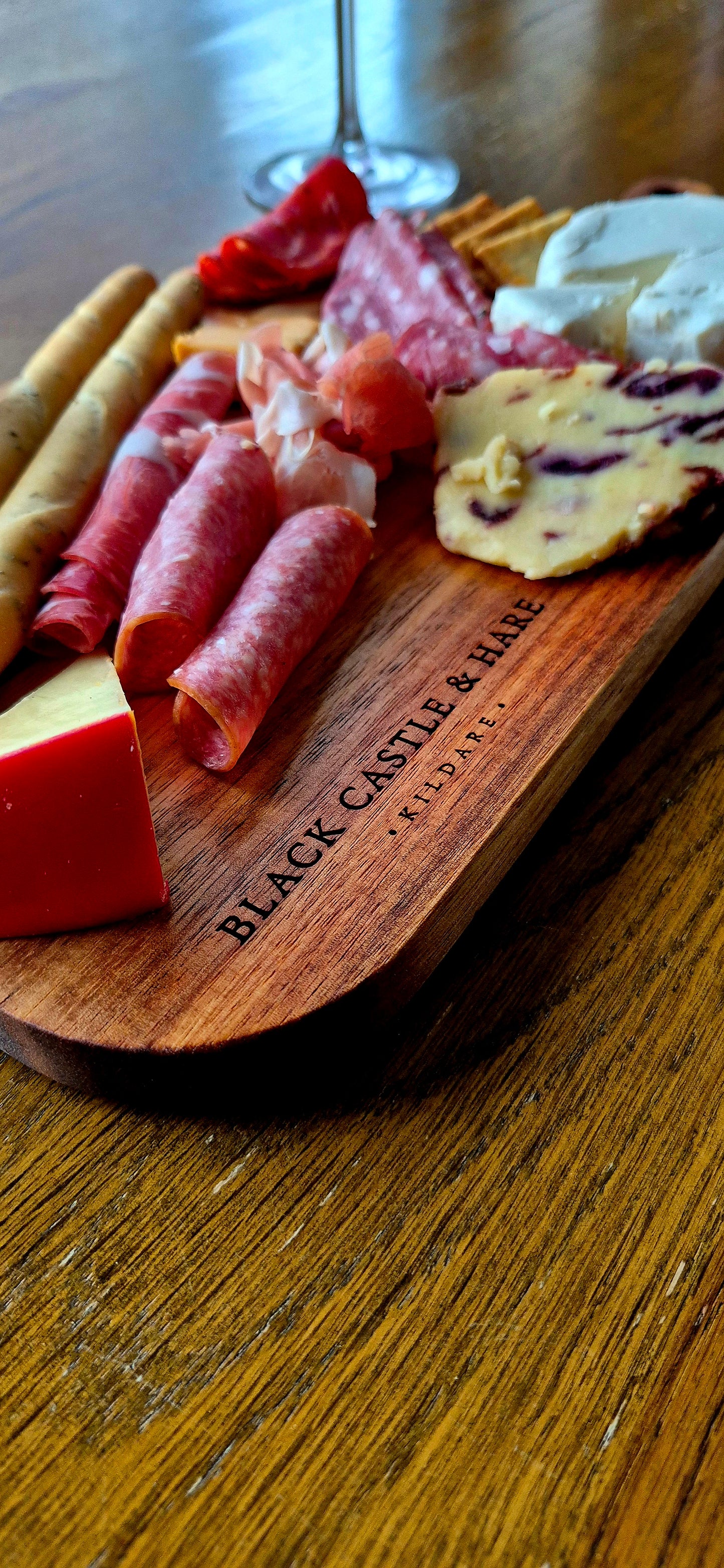 Close-up of Black Castle & Hare Kildare logo on a 15mm thick food-safe acacia wood charcuterie board for 10 people.