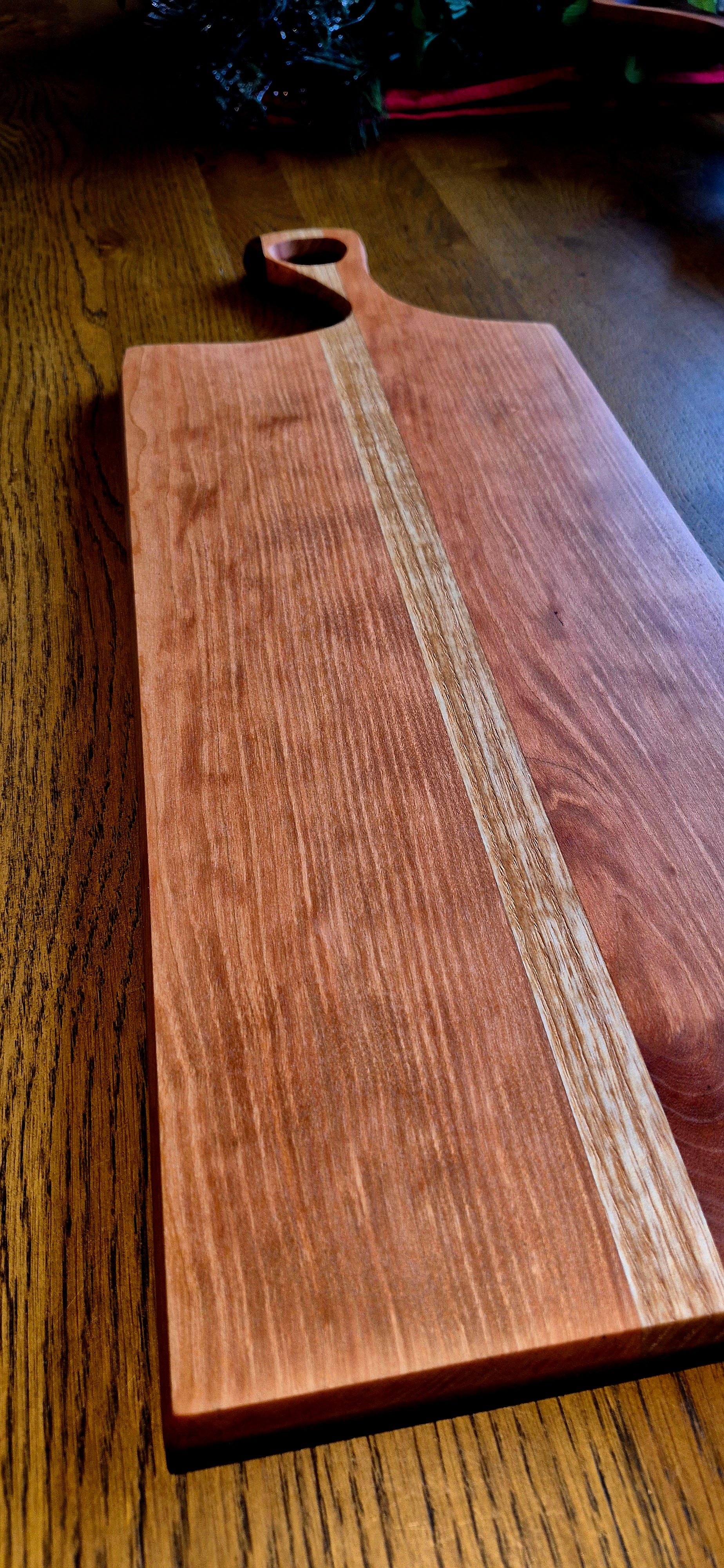 Detailed grain of cherry wood with dark walnut accents on a serving board