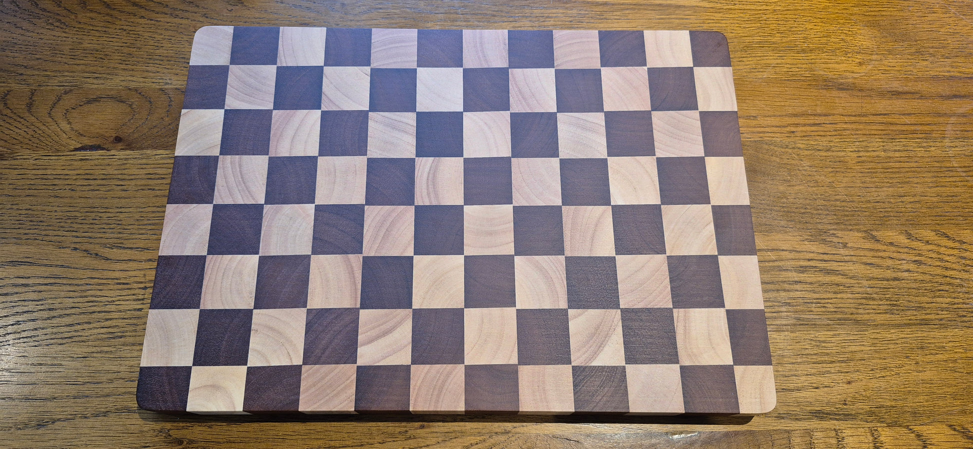 Checkered wooden cutting board on a wooden surface