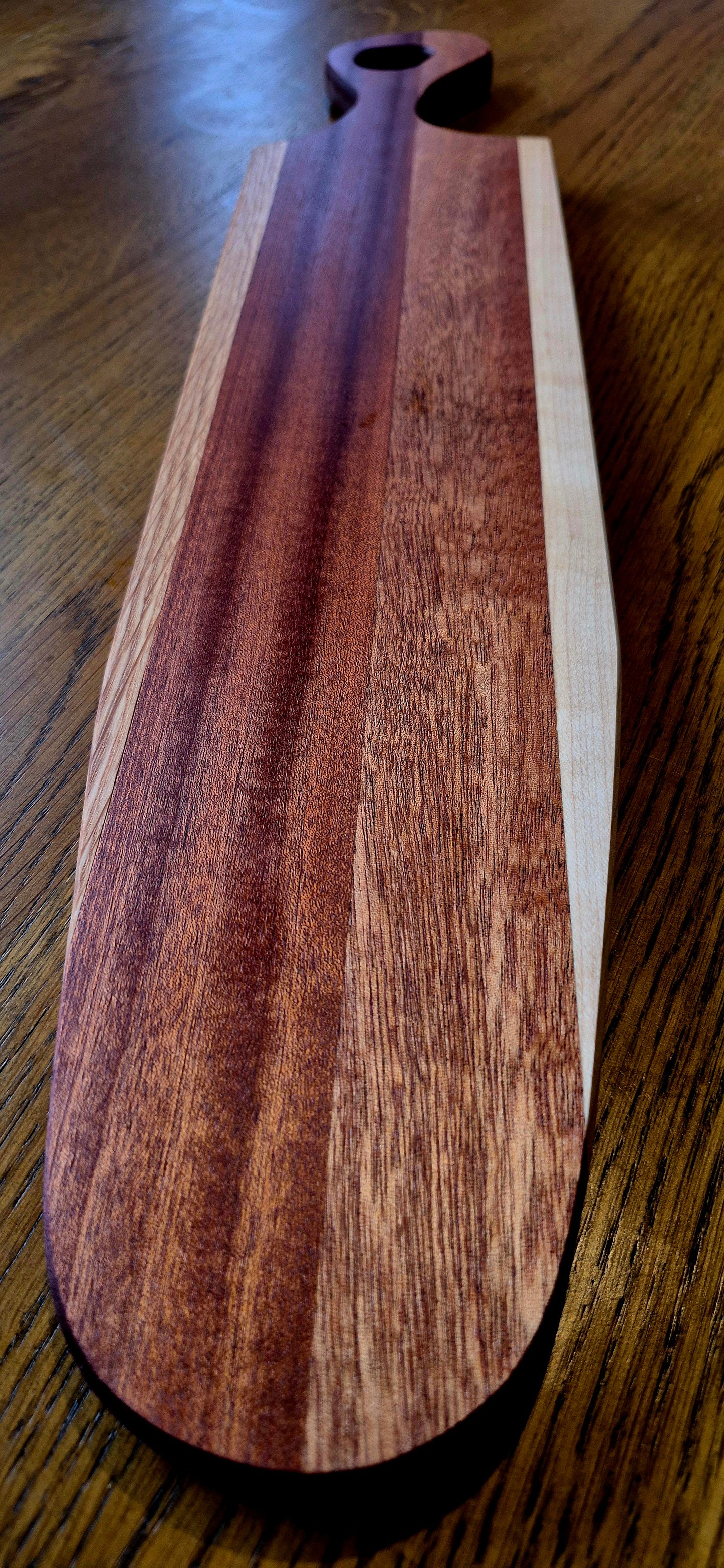A handcrafted striped cheese board made from premium White Oak, Poplar, and dark Sapele Mahogany with a food-safe oil finish.