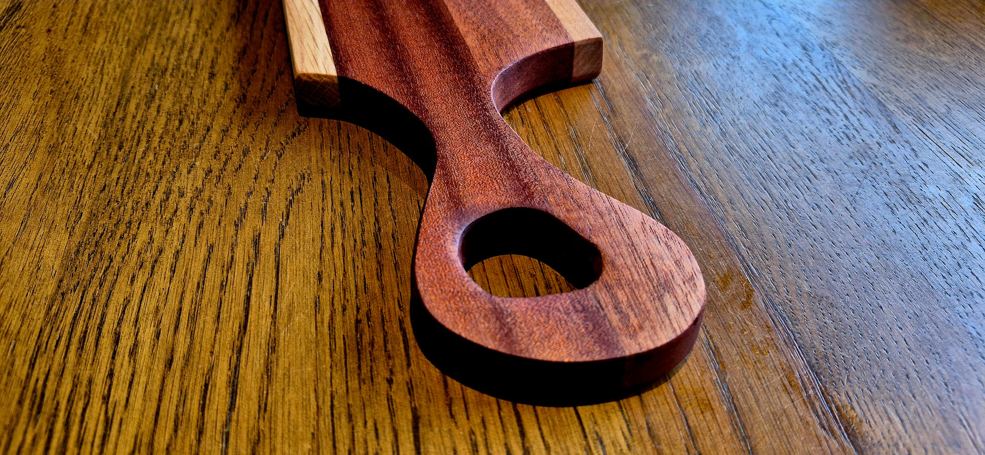 Close-up of the natural wood grain and high-quality joinery on a handmade Oak and Sapele Mahogany striped serving board